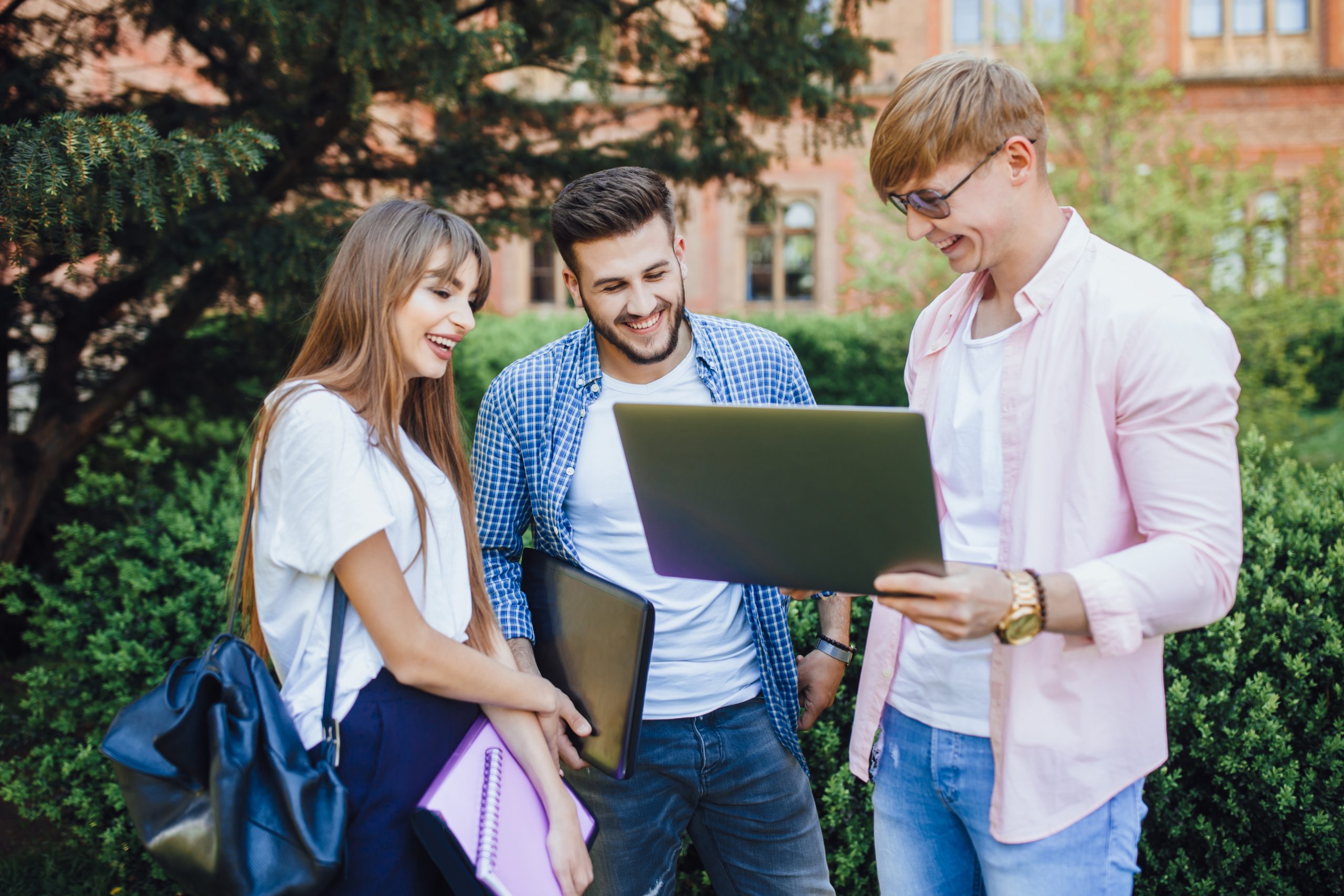 three-students-stylish-clothes-look-laptop-laugh-university-campus-scaled.jpg